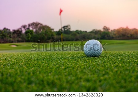 A long putt on the  green as sunset closes in