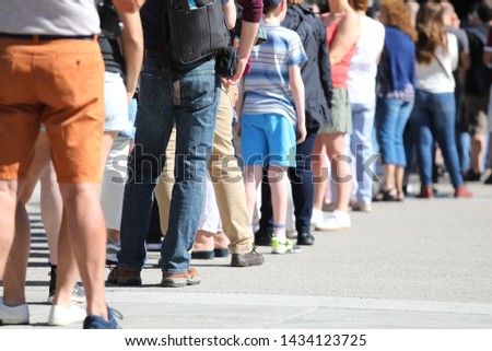 Long queue of people waiting in line