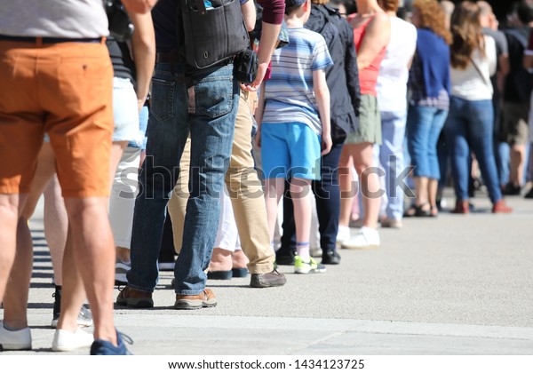 Long queue of people\
waiting in line
