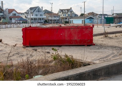 A Long Red Dumpster On The Sand By The Beach