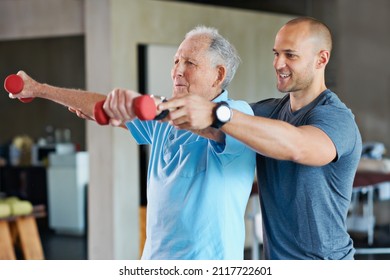 The long road to physical rehabilitation. Shot of a physiotherapist helping a senior man with weights. - Shutterstock ID 2117722601