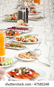 Long Served Restaurant Table With Snacks And Salads