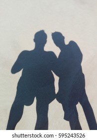 Long Shadow Of Two Friends On Beach Sand