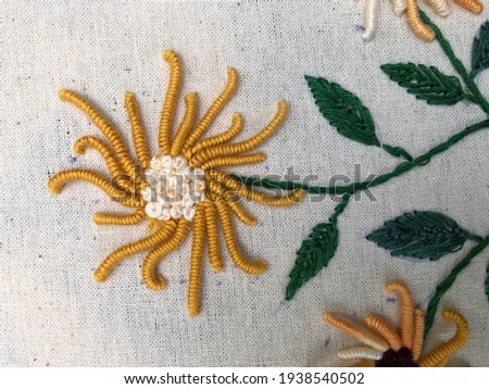 Long and short Boolean stitch flowers with leaf stitches on fabric 