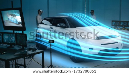 Long shot of scientists using vr technology to simulate aerodynamic properties of car