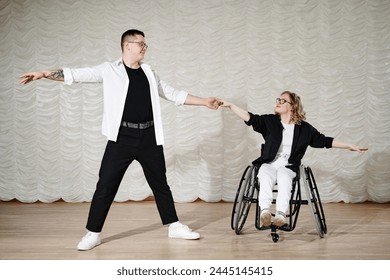 Long shot of young Caucasian man and woman with disability in wheelchair performing dance on stage, copy space - Powered by Shutterstock