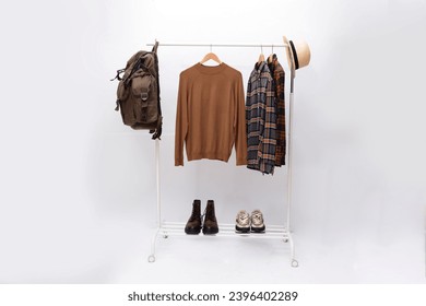 long sleeved ,striped ,plaid shirt,brown sweater, backpack on hanger with two shoes  - Powered by Shutterstock