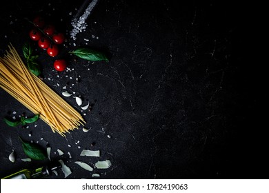 Long Spaghetti With Cherry Tomatoes, Sea Salt Garlic And Olive Oil On The Black Concrete Table. Overhead Shot Of Italian Pasta With Ingredients On The Dark Background