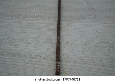 a long steel stick on a concrete floor 