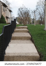 The long steps by the railing eventually reach the bottom.
