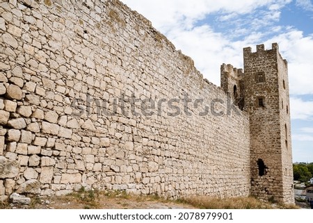 A long stone wall of a historical building going to the observation tower. Ancient buildings, their historical value. Stone constructions. High quality photo