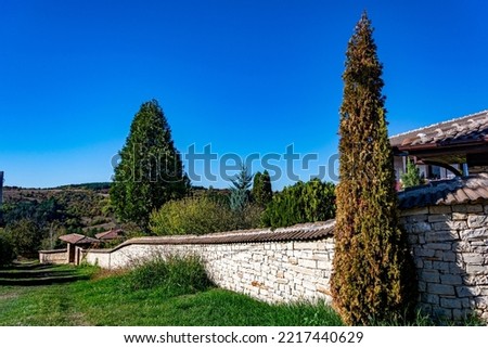 Long stone wall in perspective of an ancient traditional house in Arbanasi, Veliko Tarnovo, Bulgaria on a bright sunny day