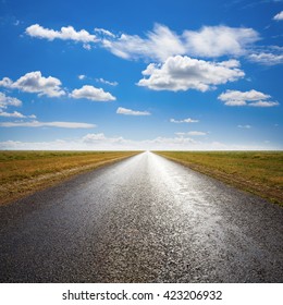 Long Straight Desert Road To Flat Horizon, With Light Streaming From Straight Ahead. 