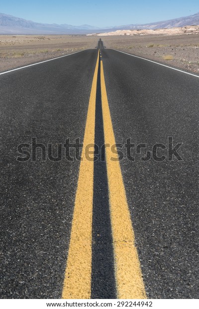 Long straight road in the desert of Death\
Valley, California