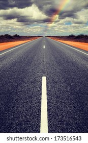 Long Straight Road In Western Australia With Gathering Storm Clouds Overhead. Concepts Of Trouble Ahead And Finding A Way Through. Road Is Symmetrical Has Been Mirrored.