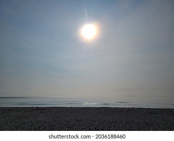 A Long Stretch Of Beach Line In Nova Scotia With Dog And People Foot Prints Running Across It On An Overcast Day With The Sun Above.