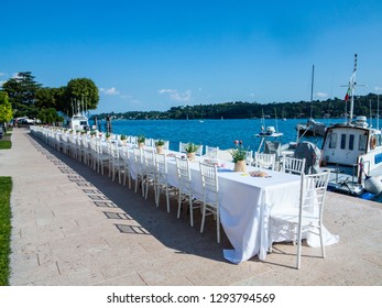 Long Table For A Dinner Event At The Edge Of The Lake In Salò-Garda Lake-Italy