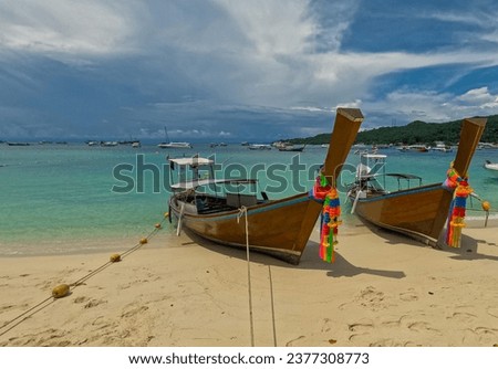 long tail Boat Phi Phi island one of the wonders of beauty just off the coast of phuket thailand. Phi phi island is famous for turquoise clear blue waters teaming with Corel reef fish white soft sand 