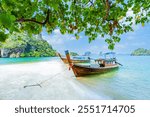 Long tail boats on a white sandy beach on an island in the Andaman Sea, Krabi Province, Southern Thailand, Asia.