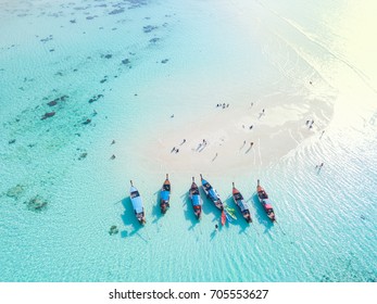 Long tail boats at sand bar beach with crystal clear water of the tropical island in Thailand