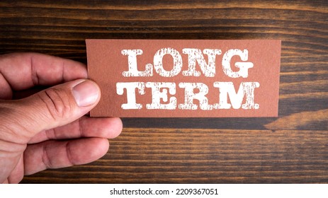 Long Term. Piece Of Paper With A Text In A Man's Hand.