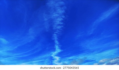 Long thin cloud formation resembling a smoke plume in the clear blue atmosphere