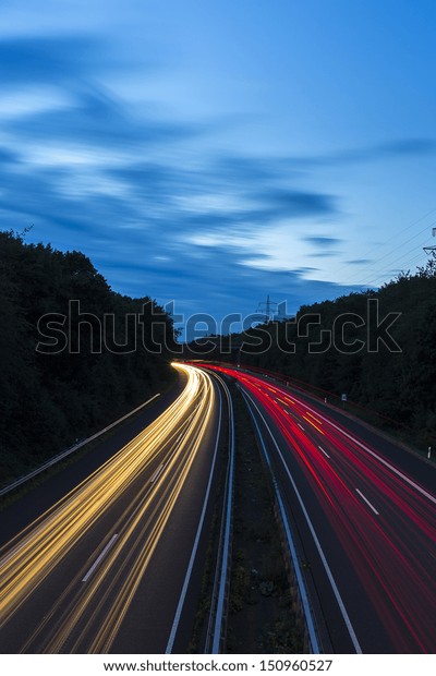 long time exposure on a highway with car light\
trails at blue hour