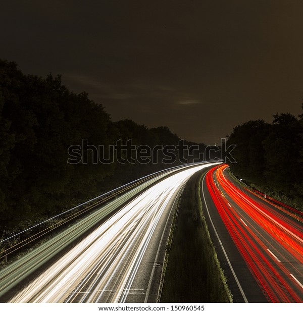 long time exposure on a highway with car light\
trails at night
