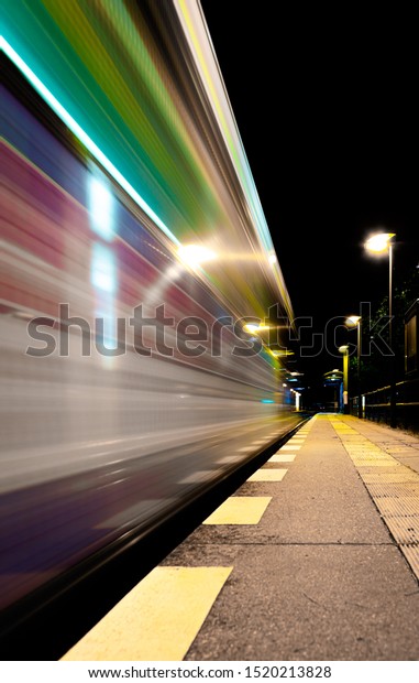 long time exposure shot from a\
starting strain next to a station platform at night\
