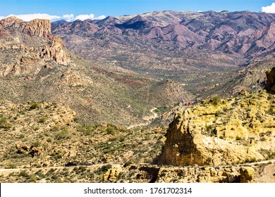 Long Trail Winding Through The Desert With A Pickup Truck Hauling A Boat On A Dirt Road