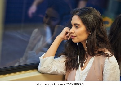 Long Train Rides Are Great For Just Thinking. Cropped Shot Of A Young Attractive Woman Listening To Music While Commuting With The Train.