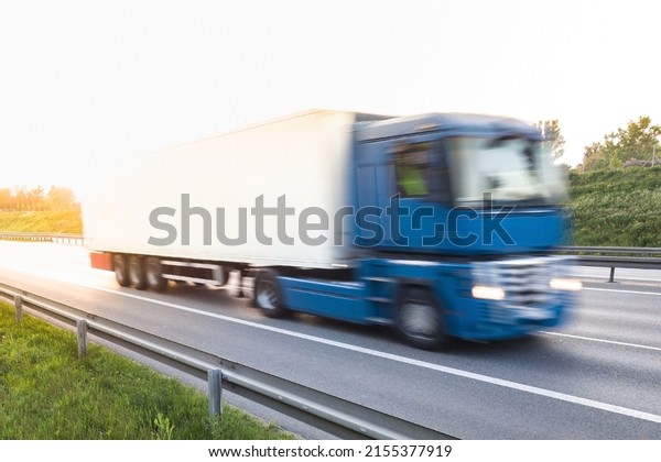 Long vehicle trailer truck on a highway with\
motion blur effect.