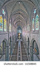 A long view down the aisle of the Gothic Basilica del Voto Nacional with high vaulted ceilings and stained glass in the historic center of Quito, Ecuador, a reverent space.