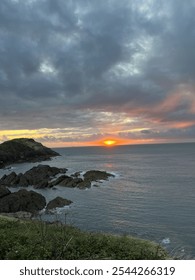 Long view of the sun setting over the sea
