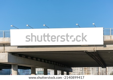 Long white empty signboard hanging on concrete urban bridge for commercial information and advertise message