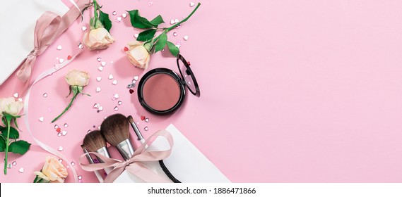 Long wide festive banner with make up set, brushes, gift bags with ribbons, aromatic rose flowers and shining confetti. Festive cosmetic sale banner. St. Valentine’s Day concept. - Powered by Shutterstock
