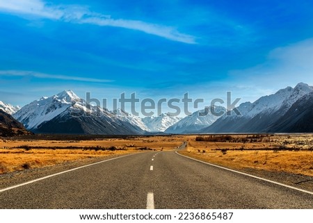 The long and winding  road heading towards Mt Cook Village in the national Park surrounded by the snow covered Southern Alps