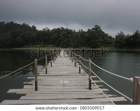 Long wooden bridge to the end of the river