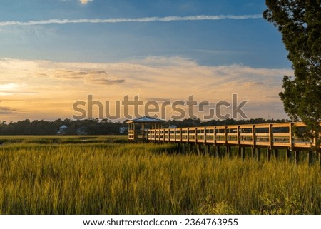long wooden dock on the inlet at Pawleys Island in South Carolina in warm golden light at sunset