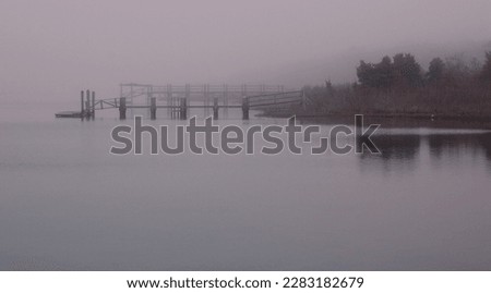 A long wooden pier on a foggy morning on Cape Cod
