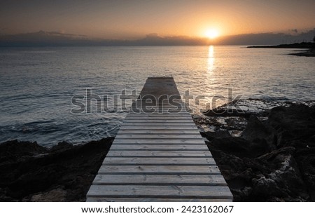 Long wooden pier in the sea at sunrice. Protaras Cyprus