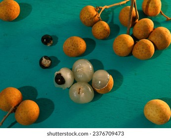 longan fruit or ( Dimocarpus longan, Lengkeng, kelengkeng, mata kucing,  Lungen, Dragon's Eye, 龙眼 ) on a turquoise wooden board