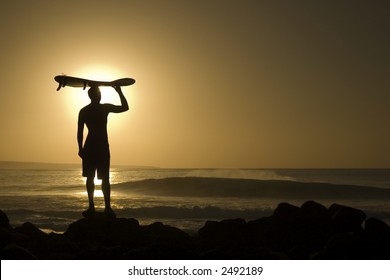 A longboarder watching he waves at sunset in La Santa Lanzarote