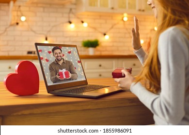 Long-distance relationship and virtual date in lockdown. Young couple in love video calling each other during quarantine and showing gifts and presents they prepared for Saint Valentine's Day - Powered by Shutterstock