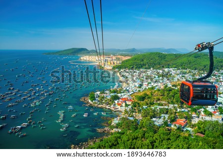 The longest cable car situated on the Phu Quoc Island in South Vietnam and below is traditional fishermen boats lined in the harbor of Duong Dong town in the popular Hon Thom island. Travel concept.