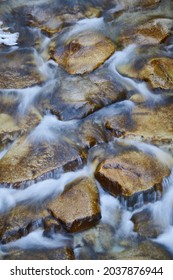A longexposure photography of the stream of a river and the rocks