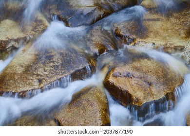 A longexposure photography of the stream of a river and the rocks