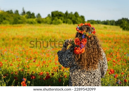 Similar – Image, Stock Photo Long-haired curly woman plus size in a wreath of red poppies stands among a field of meadow flowers and covers her face with a bouquet of poppies