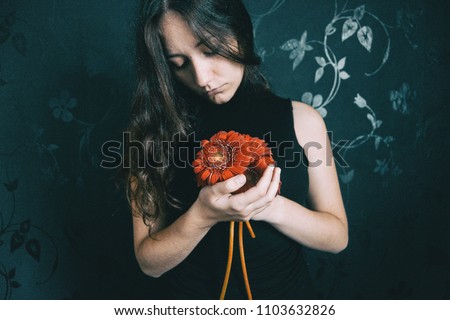 Similar – ein Mädchen mit blauen Augen und langem Haar, das sich mit einer Gerbera-Blüte bedeckt