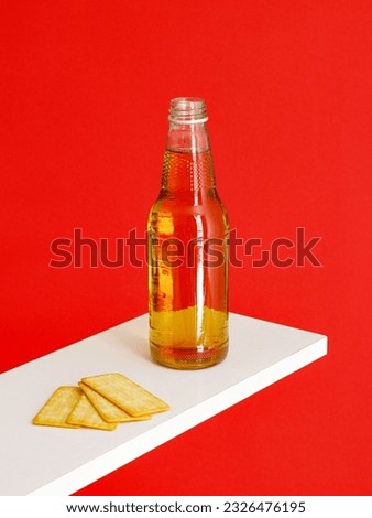 A Longneck beer bottle and Cracker Biscuit isolated on red background